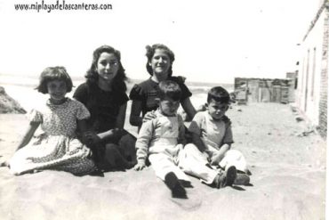 Dora Suárez, Olga y Nora Santana, Juan Ambrosio en 1954. Sentados sobre una duna de arena, atrás se ve lo que actualmente es la C/ Portugal- colecc. Elena Santana Auyanet.