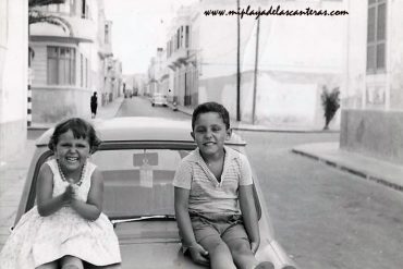 Margarita  Artiles con su hermano Rafael sobre un coche en la esquina de las calles Luis Morote y Bernardo de La Torre,  sobre 1960.  Familia Artiles Ramírez