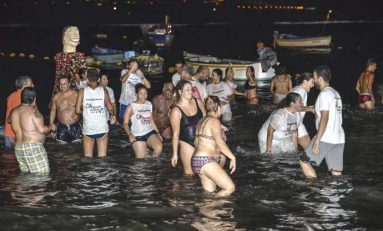 El tradicional chapuzón de las Fiestas de La Naval congrega a numerosas personas en el entorno de La Puntilla