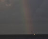 Un velero iluminado por un arcoíris